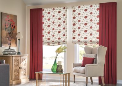 Red drapes and floral shades on living room windows